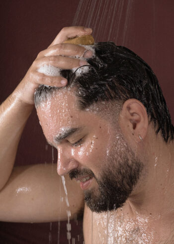 homem a lavar o cabelo com champô natural diário