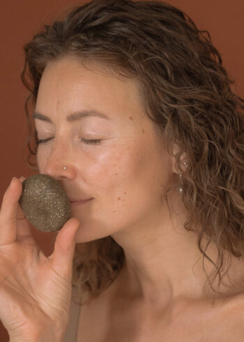 mulher a cheirar champô sólido natural