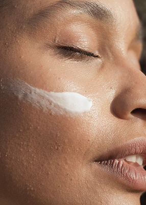 Aplicação do Creme ao Sol mulher com creme de rosto natural ao sol